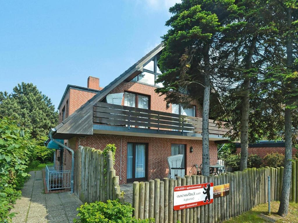 a brick house with a wooden fence in front of it at Ferienwohnung in Westerland auf Sylt in Westerland
