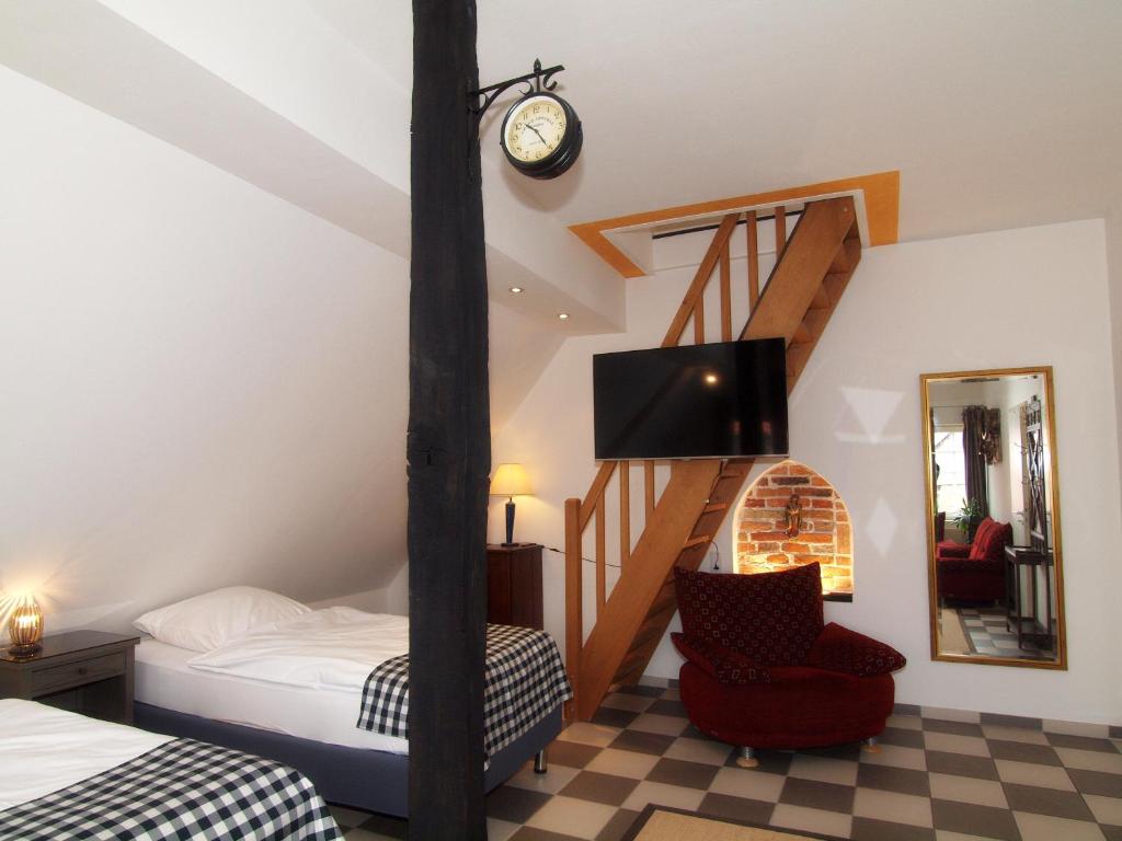 a bedroom with a bed and a staircase with a tv at amazing historical appartment in Sendenhorst