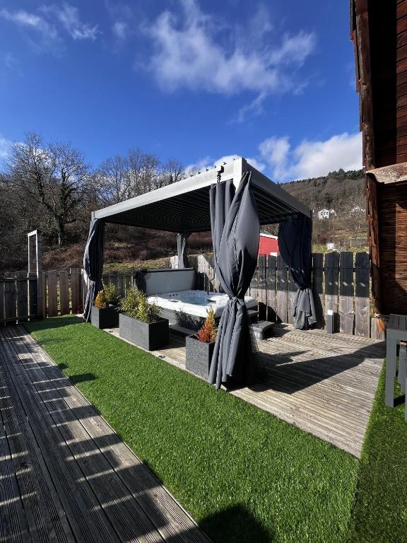 un auvent noir et gris sur un pont avec de l'herbe dans l'établissement A Casita del Pedro, à Rimbachzell