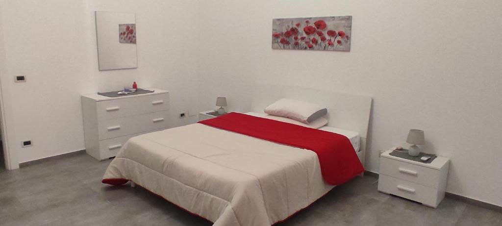 a white bedroom with a bed and two night stands at Sweet home in Casa Santa