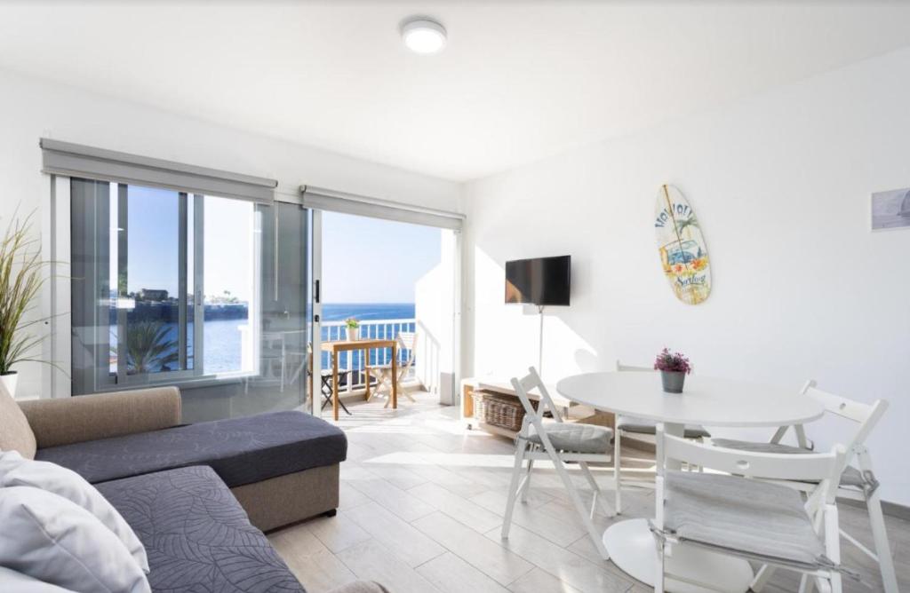 una sala de estar con un sofá y una mesa en Atardecer 1, en Puerto de Santiago