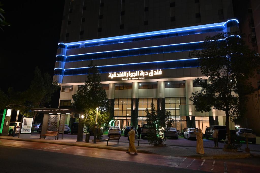 a building with a blue lit up sign on it at درة الجوار in Al ‘Azīzīyah