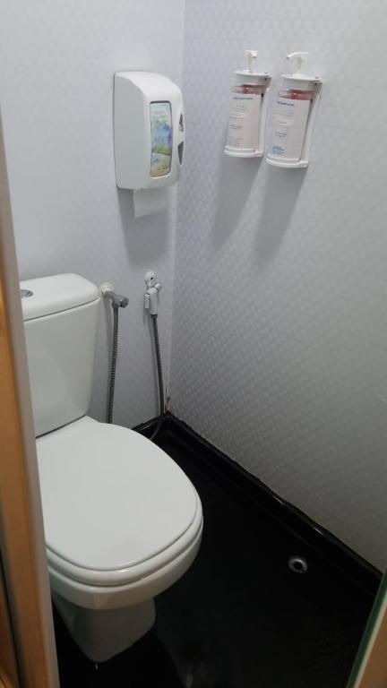 a bathroom with a white toilet and a paper dispenser at Hotel Aero Sleep Campinas in Campinas
