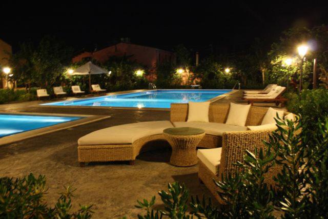 basen z krzesłami i kanapa obok basenu w obiekcie Ville dell'Eden con 9 camere da letto in 6 unità abitative w mieście Lascari