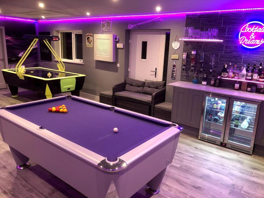 a billiard room with a pool table and a bar at Studio Apartment with games room in Royal Wootton Bassett