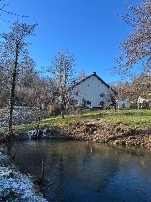 une maison à côté d'une rivière avec une maison dans l'établissement La Couchette, à La Rosière