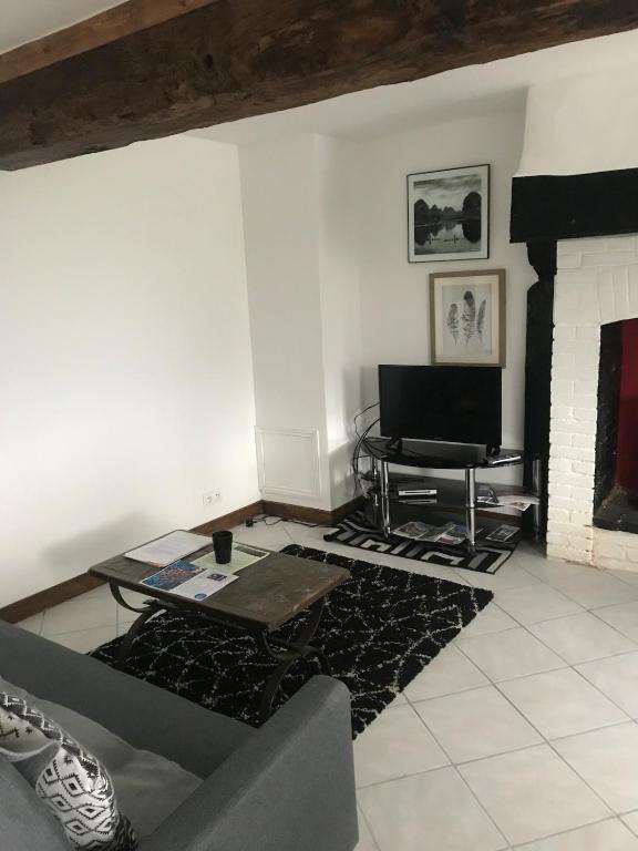 un salon avec une table et une cheminée dans l'établissement Charming Gite in the Normandy countryside, à Saint-Mars-dʼÉgrenne