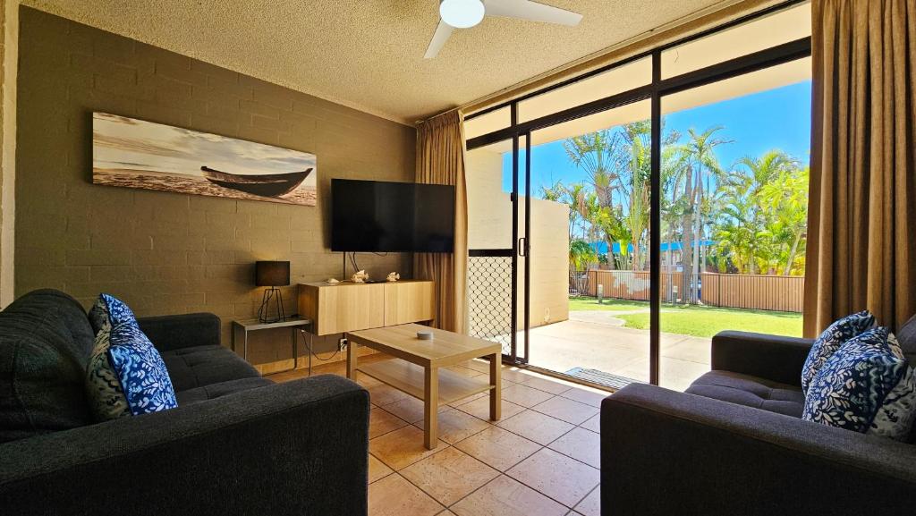ein Wohnzimmer mit zwei Sofas und einem Fernseher in der Unterkunft Riverview Holiday Apartment 60 - Kalbarri WA in Kalbarri