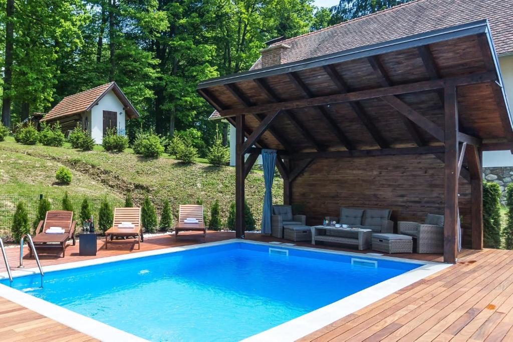 a pool with a wooden deck and a pavilion with a swimming pool at Holiday House Papuk in Novo Zvecevo