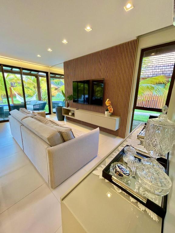 a living room with a couch and a table at Bangalô com 3 suítes no Eco Resort na Praia dos Carneiros in Tamandaré