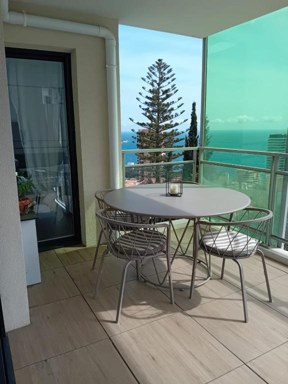 une table et des chaises sur un balcon avec vue sur l'océan dans l'établissement Luxury Apartment MonacoView, à Beausoleil