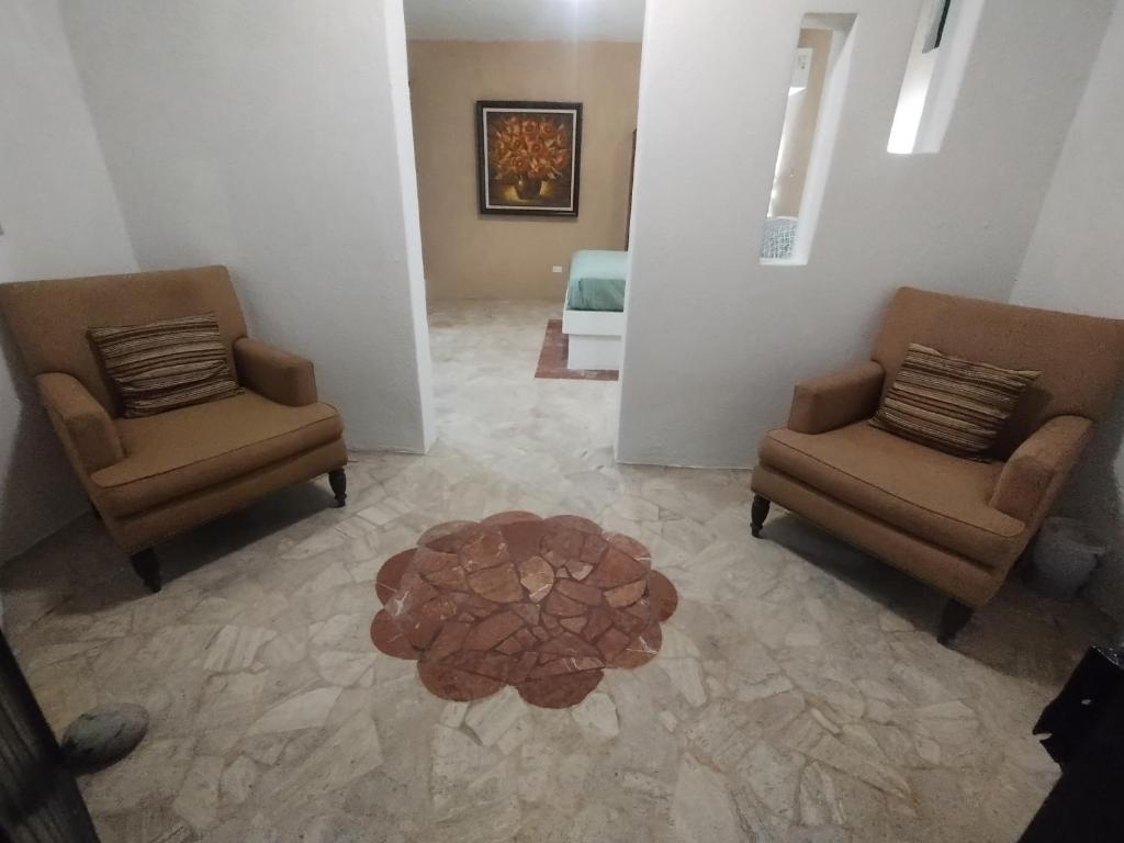 a living room with two chairs and a table at Tres Migueles Depa Shaaro cerca marina y playa medano in Cabo San Lucas
