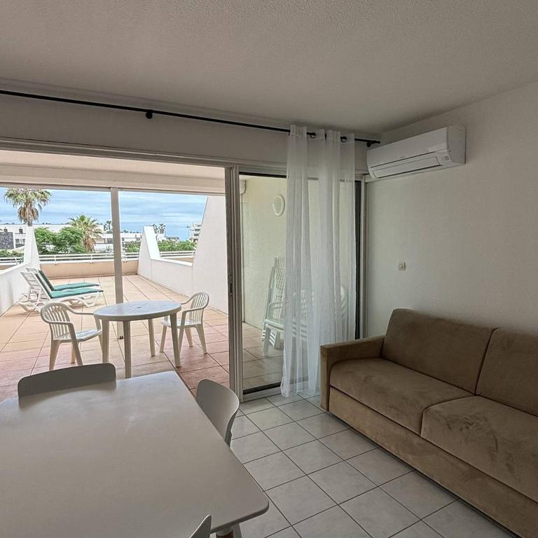 un salon avec un canapé et une table dans l'établissement Appartement 4 personnes Natura Beach 106, au Cap d'Agde