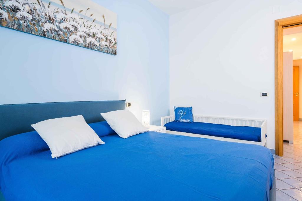 a blue bed with two pillows in a room at I Tre Delfini apartment in center-Sorrento Coast in Vico Equense