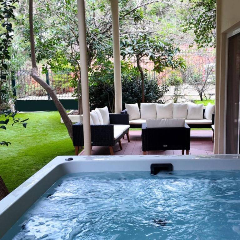 a hot tub in the middle of a yard with furniture at 4bd Apartment With Outdoor Jacuzzi Garden in Athens