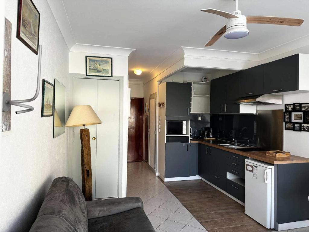 - une cuisine avec des armoires noires et un canapé dans la chambre dans l'établissement Résidence Houle - Studio neuf pour 2, à deux pas des plages d'Arcachon MAE-8324, à Arcachon