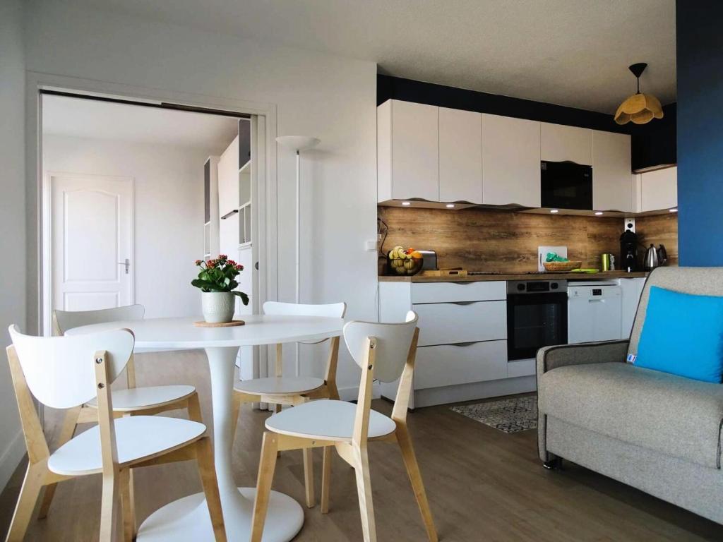 un salon avec une table et des chaises et une cuisine dans l'établissement Résidence Antares - Charmant T2 entièrement rénové avec vue imprenable sur le bassin MAE-9344, à Arcachon