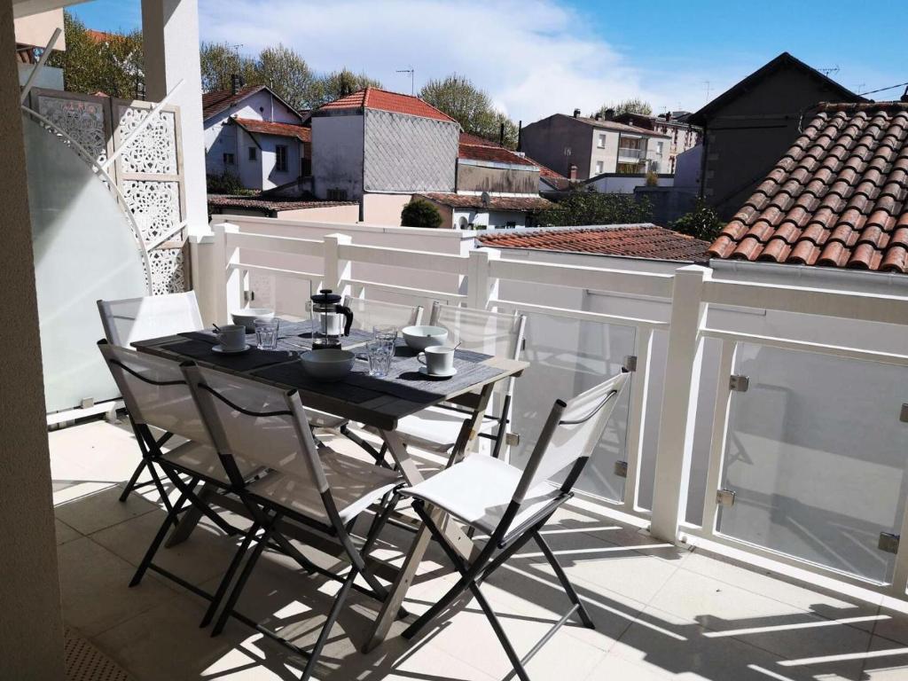 une table noire et des chaises sur un balcon dans l'établissement Résidence Dignan - Arcachon - T3 centre-ville MAE-9464, à Arcachon