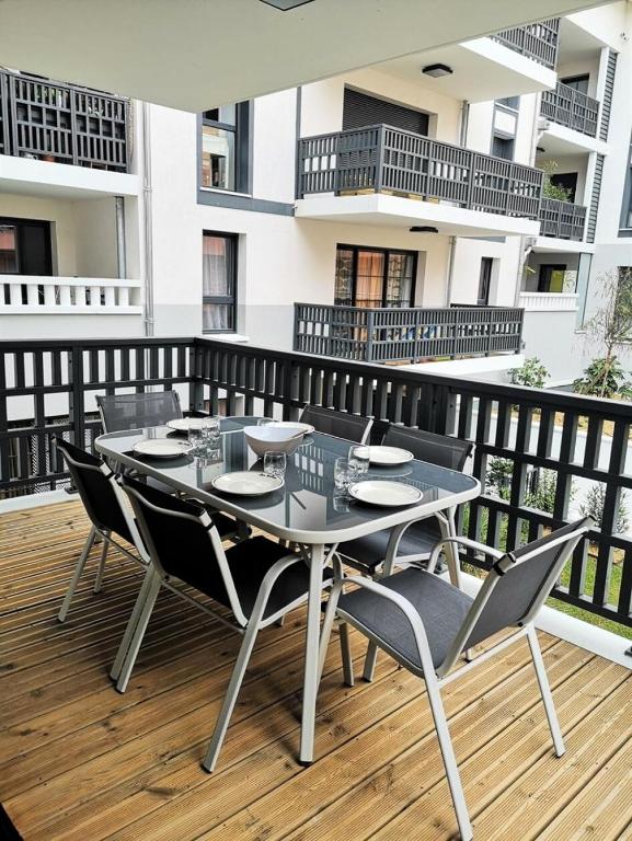 une table et des chaises sur une terrasse avec balcon dans l'établissement Résidence Villa Marine - Appartement neuf T3 au centre-ville d'Arcachon MAE-9484, à Arcachon