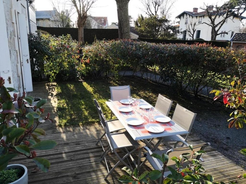 une table et des chaises assises sur une terrasse dans l'établissement Résidence Les Pins Tranquilles - Arcachon Ville d’Hiver – Charmant T3 avec Terrasse Privée MAE-9514, à Arcachon