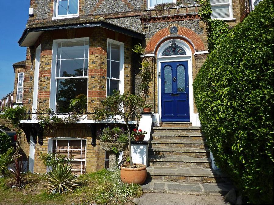 a brick house with a blue door and stairs at Broadstairs House Boutique B&B By The Sea in Broadstairs