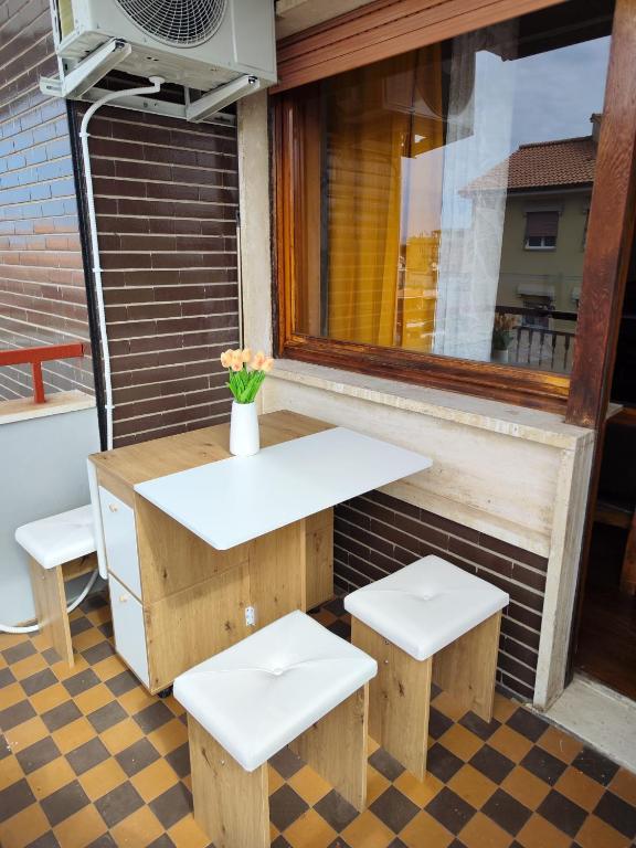 a table and two stools in front of a window at La casa di Fred in Rome