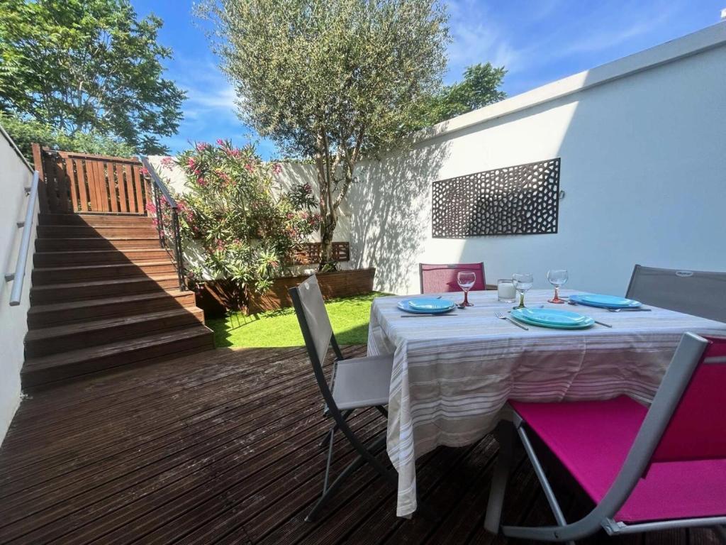 une table avec un tissu de table blanc sur une terrasse dans l'établissement Résidence Les Perlieres - Arcachon – Charmant T1 Cabine décoré avec soin, pour 2 personnes MAE-3194, à Arcachon