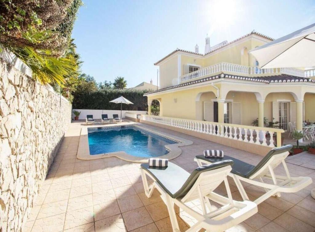een villa met een zwembad en een huis bij Casa Camarinha in Carvoeiro