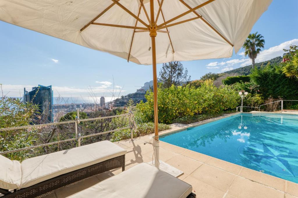 un parasol et une chaise à côté de la piscine dans l'établissement Private Pool Villa Beside Monaco, à Beausoleil