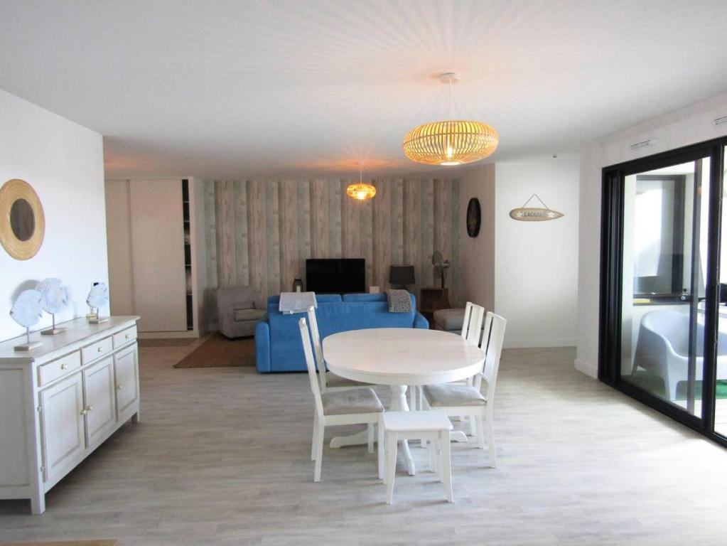 une cuisine et une salle à manger avec une table et des chaises dans l'établissement Résidence Roof Top - Appartement T3 neuf pour l'accueil de 6 personnes à 70m des plages MAE-0851, à Lacanau