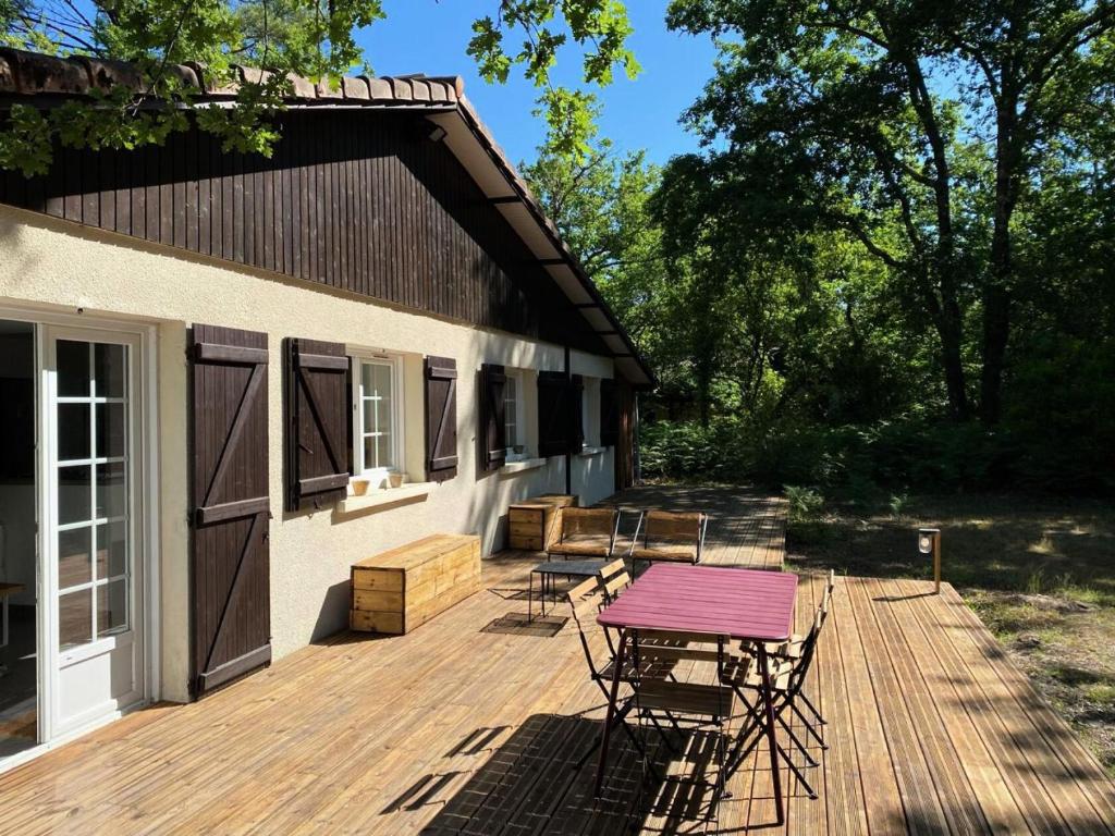 une terrasse en bois avec une table et des chaises sur une maison dans l'établissement Résidence 04094-lacanau - Maison familiale dans un complexe au calme près du lac MAE-0971, à Lacanau