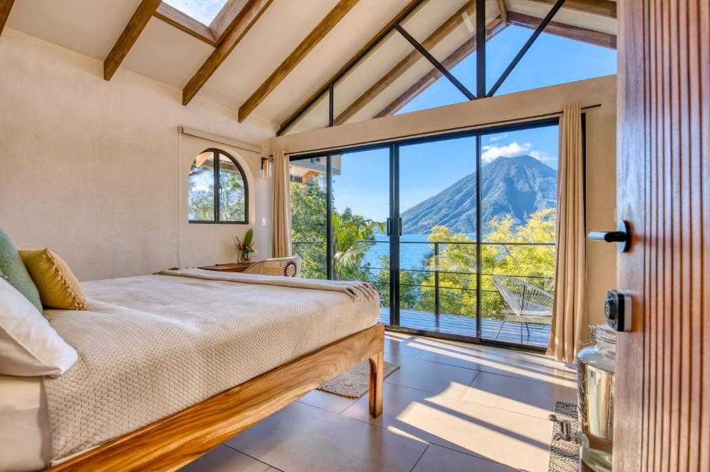 a bedroom with a bed and a large window at Tierra de la Aurora in San Marcos La Laguna