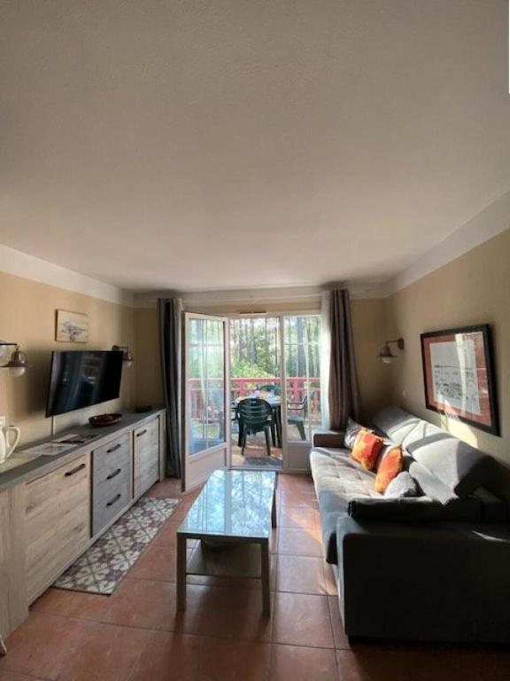 un salon avec un canapé et une table dans l'établissement Résidence Lacanau Les Pins - 01424_ Appartement T2 avec piscine collective chauffée MAE-1041, à Lacanau