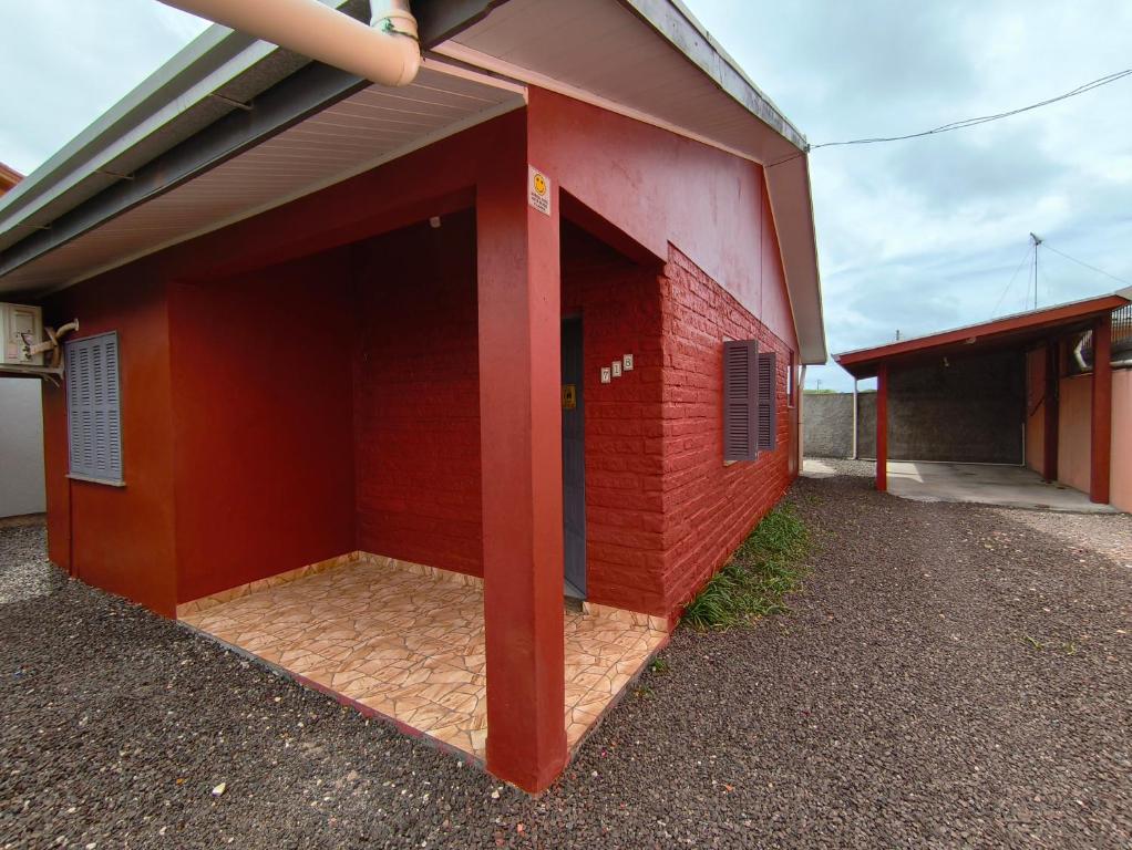 a red brick building with a large doorway at Oasis Sul Tramandaí Casa Vermelha in Tramandaí
