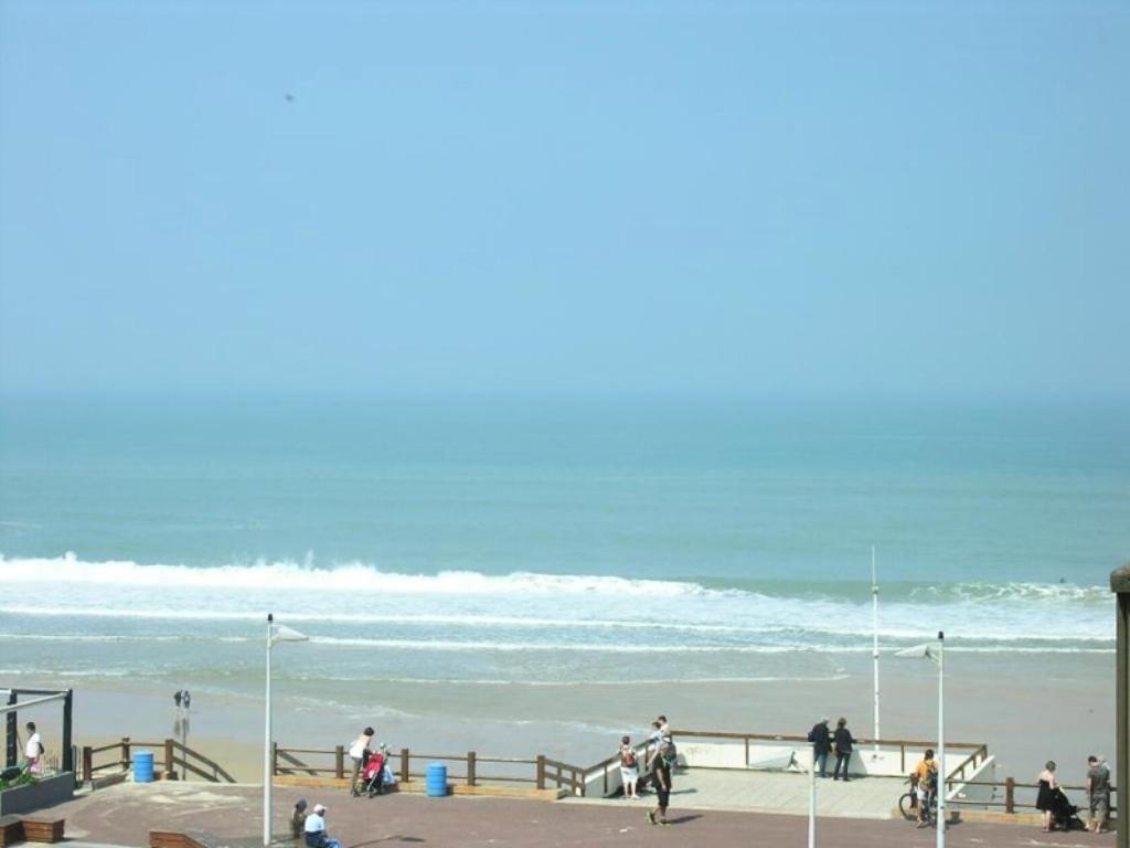 un groupe de personnes marchant sur la plage dans l'établissement Résidence Ortal - Appartement 4 personnes vue océan, orienté sud, 30m de la plage, Lacanau Océan MAE-1121, à Lacanau