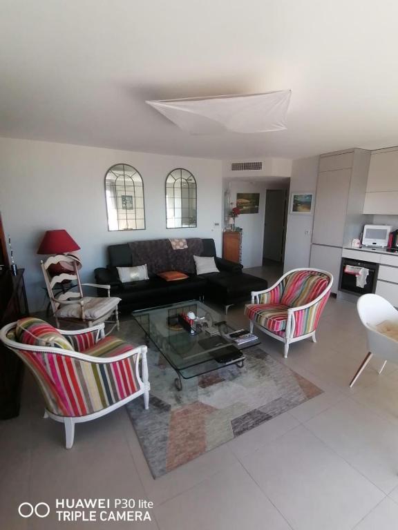 un salon avec un canapé, des chaises et une table dans l'établissement Le Syracuse, à Antibes