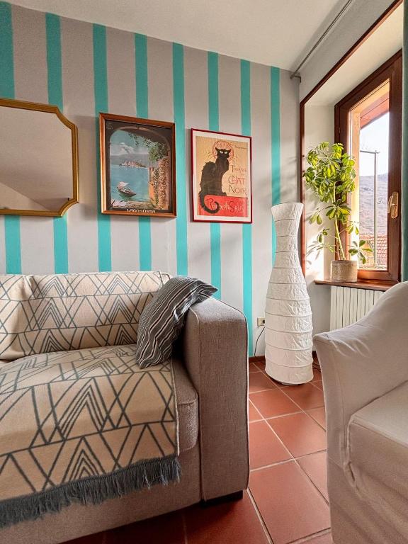 a living room with a couch and a striped wall at Oh!megna in Omegna