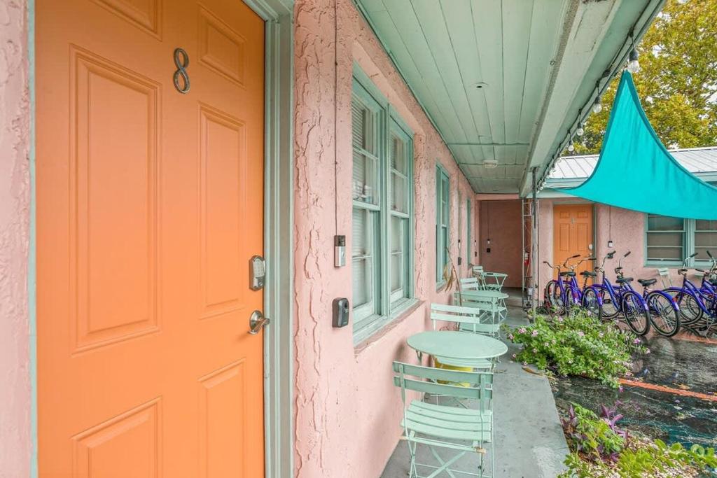 an orange door on a house with a table and chairs at Back in Time Motel- Charming 50's in St Augustine in Saint Augustine
