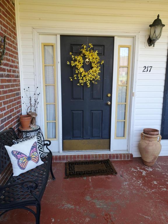 a black front door with a wreath and a bench at Cozy Charming Vintage Villa in Oxford