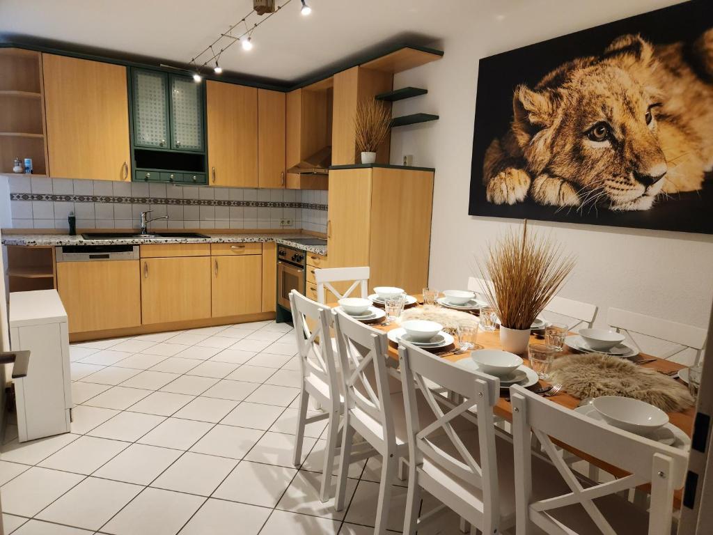 Una cocina con una mesa y un cuadro de un tigre. en FeWo Moon am Europapark Zentrum Rust, en Rust