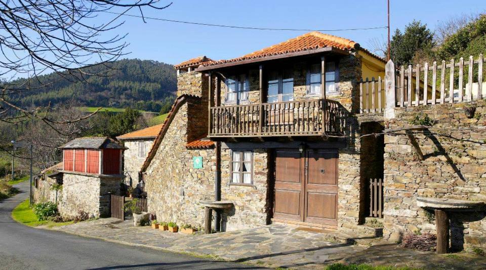 uma casa de pedra com uma varanda numa rua em Casa Rural O Carreiro em Cedeira