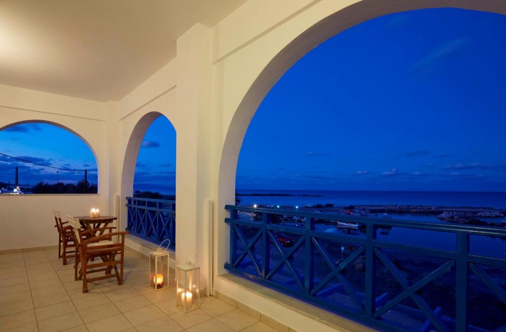 a balcony with a view of the ocean at night at Rodothea and Adams on the Beach, Santorini in Monolithos