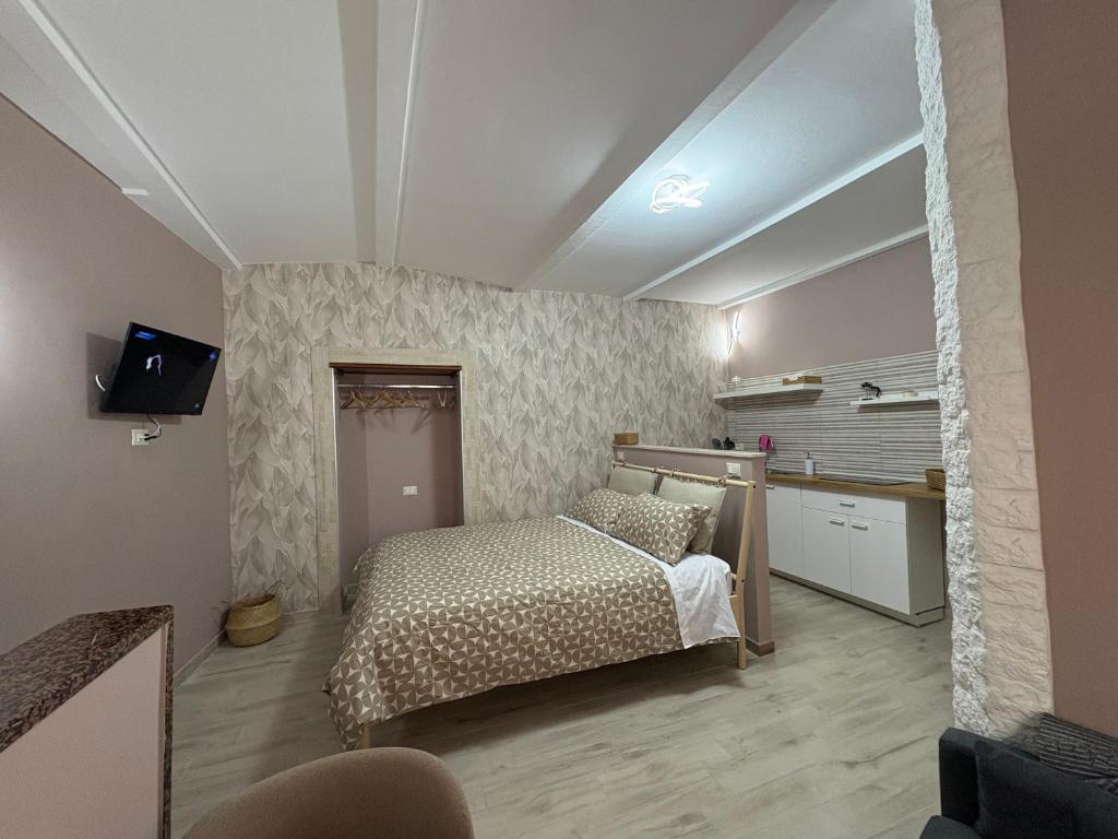 a small bedroom with a bed and a kitchen at B&B del Gatta in San Severo