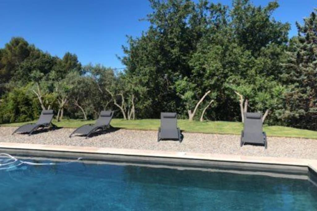 trois chaises longues assises à côté d'une piscine dans l'établissement Maison au pied du lubéron, à Lauris