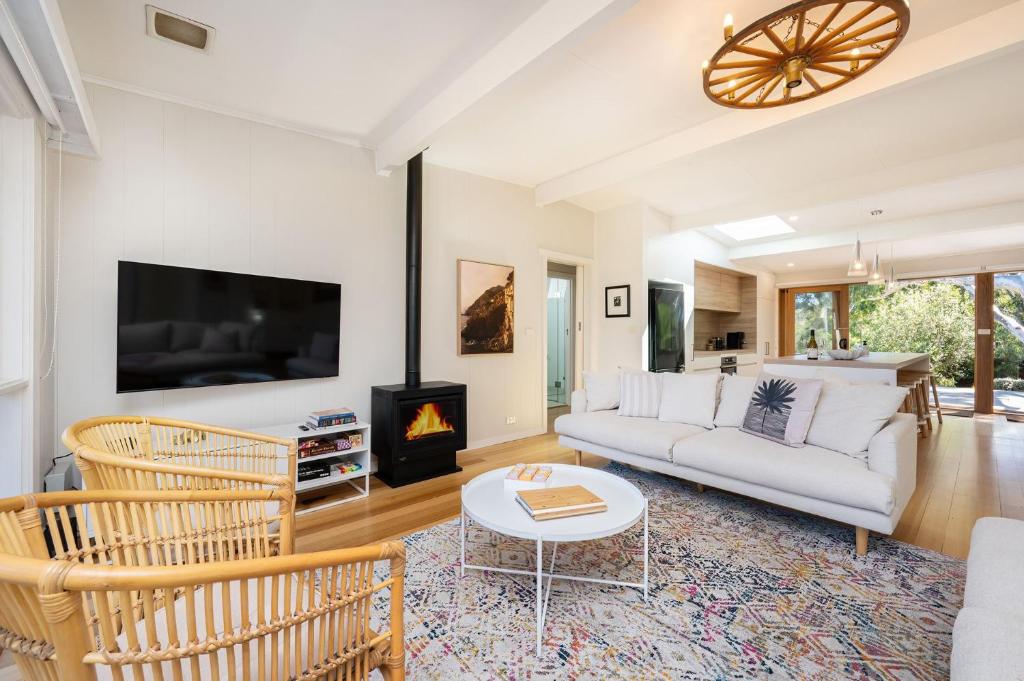 a living room with a white couch and a fireplace at Arlo Beach House - Beachside, Pet Friendly, Fireplace in Somers