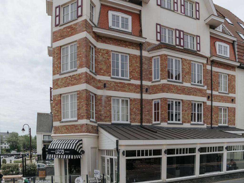 デ・ハーンにあるApartment in De Haan with Stunning Sea Viewsの店舗付きの高いレンガ造りの建物