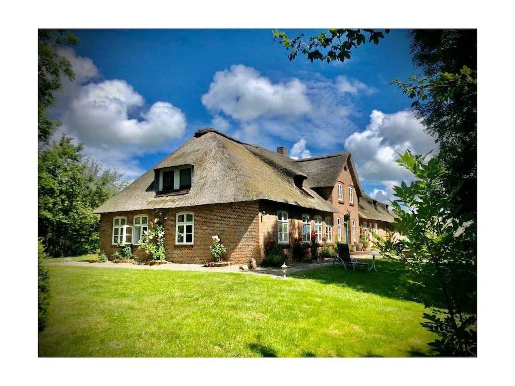 a large brick house with a thatched roof at 1-bedroom apartment in Tating