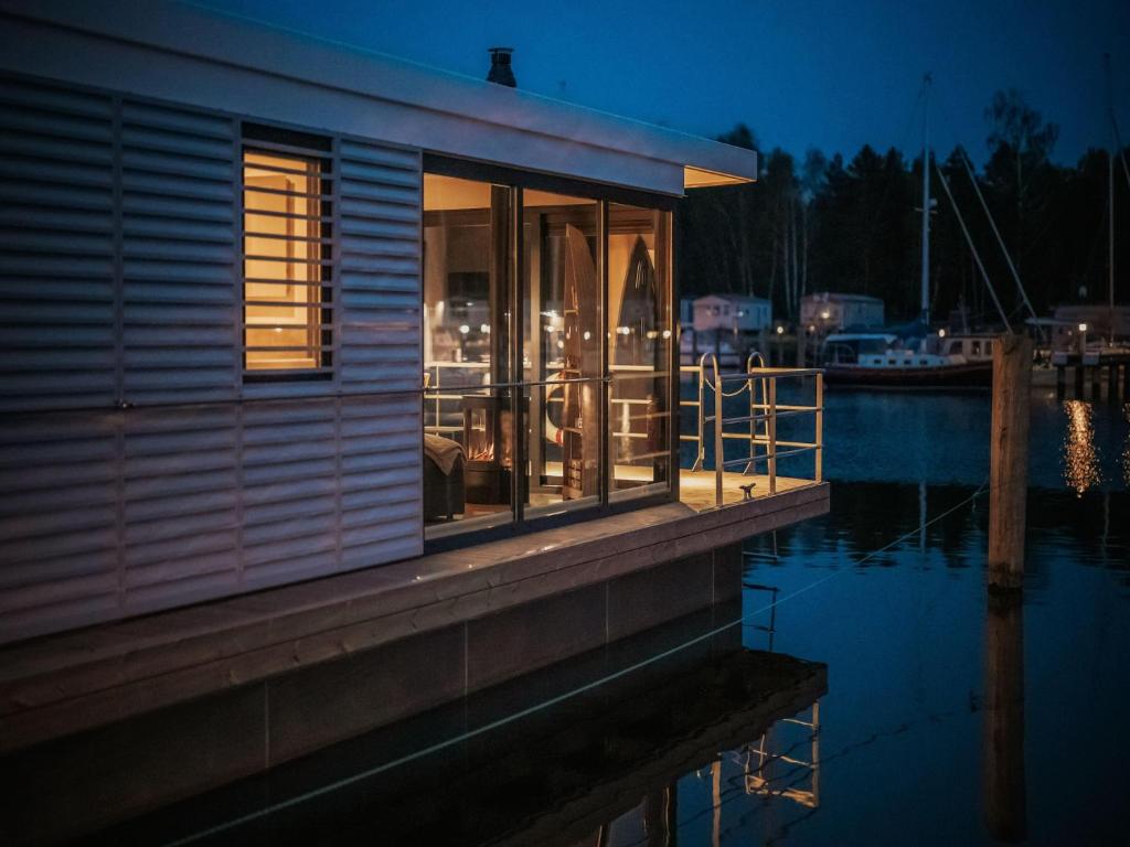 a small house on a dock next to a body of water at Floating Comfort in Peenemünde in Peenemünde