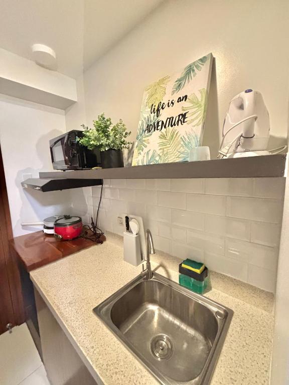 a kitchen counter with a sink and a bag on a shelf at Cebu Property Express in Cebu City