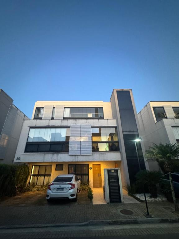ein Auto, das auf einem Parkplatz vor einem Gebäude geparkt ist in der Unterkunft Casa Residencial Recreio dos Bandeirantes in Rio de Janeiro